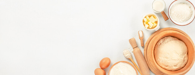 Obraz na płótnie Canvas Baking ingredients. dough flour. Cooking ingredients eggs, sugar, butter, milk, rolling pin on white background. Long banner format. top view