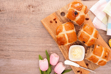 Fresh homemade Hot Cross Buns. Overhead view table scene on a  wood background with copy space....