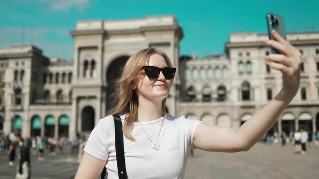 Selfie girl. Young female tourist making selfie photo with smart phone near of the famous Duomo cathedral in Milan. Happy vacations in Milan. High quality FullHD footage