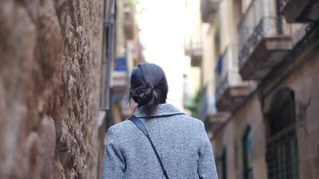 A solitary female traveler wanders through the enchanting streets of Barcelona, her camera capturing the city's vibrant essence. Immersed in the city's architectural wonders and bustling energy