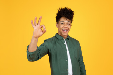 Positive black guy showing okay gesture, yellow background