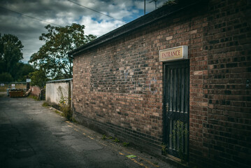 Fototapeta na wymiar Silgle door in a red brick building looks abandon, Nantwich, Cheshire, UK