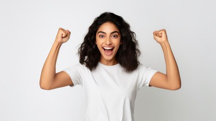 Success Celebration. Girl with Smartphone Fist Pump - Casual Attire, White Wall Background - Exciting Reward Message Received - obrazy, fototapety, plakaty