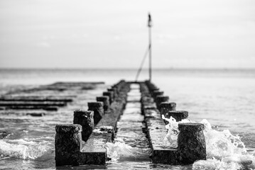 Obraz premium Old wooden remains of pier in black and white close to Lancing, West Sussex, UK