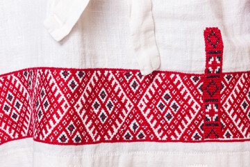 A fragment of Slavic national embroidery, a handmade embroidered shirt, embroidered with red and black threads.