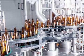Precision Beer bottling machinery with empty bottles at brewery, modern conveyor line of food...