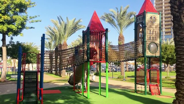 Boy paly on park. Beautiful bright children's playground. Fairytale castle, tunnels and slides for children. Kindergarten, walk in the park. Multi-colored sun awning,