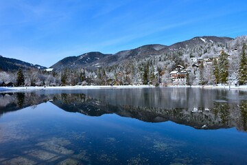 Shore of lake Jasna near Kranjska Gora, Gorenjska, Slovenia and forest covered Karavanke mountains in the background in winter