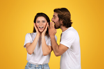 A cheerful young woman in a white t-shirt is surprised and delighted as a man