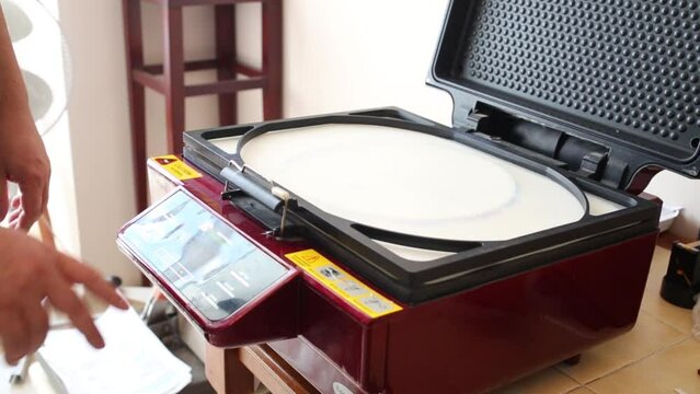 Man is closing top on airfree subliminal press with circle form.