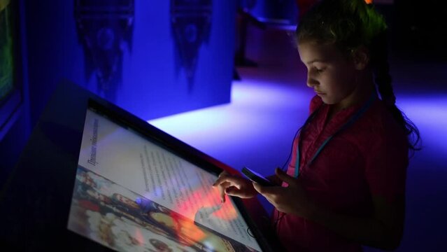 Girl touch audioguide and interactive screen in history park Russia