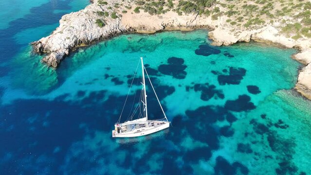Aerial drone cinematic video of sail boat anchored in tropical paradise exotic island bay with emerald crystal clear waters in Caribbean destination