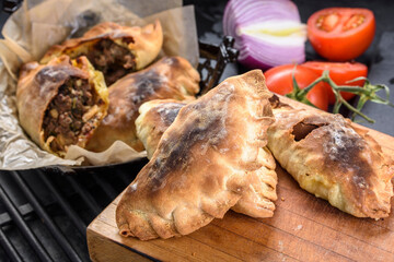 Close-Up of Homemade Fresh Beef Stuffed Empanada with Fresh Tomatoes - Appetizing 4K Ultra HD Image of Savory Pastry