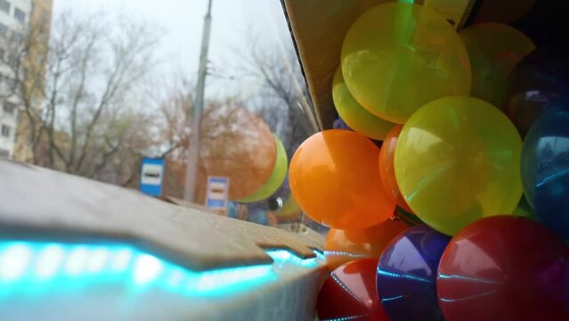 Bunch of balloons is in the car near multicolored LED strip light