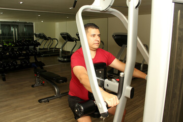 40-year-old dark-skinned Latino man does exercise to exercise his arm and chest as rehabilitation...