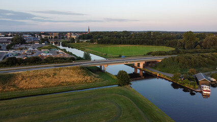 Aerial drone view of the canal and the Ruksveense Brug bridge in Steenwijk, Overijssel, The Netherlands. With the city centre, homes and the Steenwijker toren in the background.