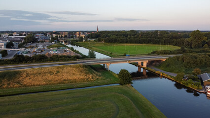 Aerial drone view of the canal and the Ruksveense Brug bridge in Steenwijk, Overijssel, The Netherlands. With the city centre, homes and the Steenwijker toren in the background.