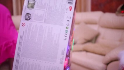 Boy plays with a big box from toys putting it on himself - Powered by Adobe