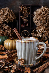 Pumpkin spice latte in mug  on wooden table, selective focus