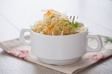 sauerkraut with carrots and spices in a white bowl