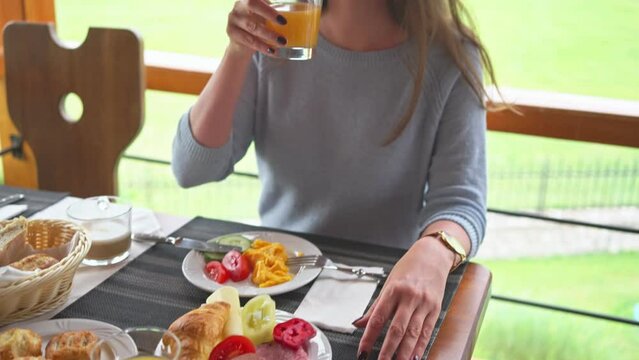 Woman eating breakfast in holiday resort, hotel restaurant or at home on terrace.
