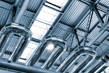 Metal pipes in an industrial building, view from bottom to top. Industrial concept background