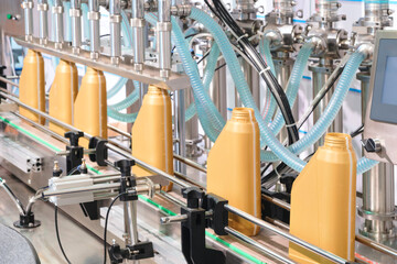 Production line on a conveyor for filling plastic cans and bottles