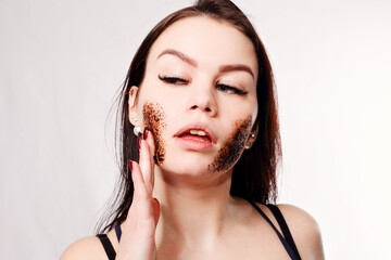 Brunette cleanses the skin with coffee scrub