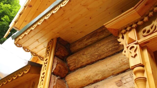 Carved frames on windows and roof on wood house close up 
