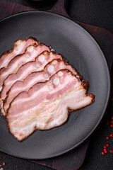 Delicious fresh pancetta or bacon with salt and spices cut into thin slices