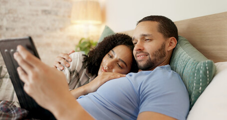 Couple, tablet and scroll in bed, morning and bond with internet video, movie and meme for love,...