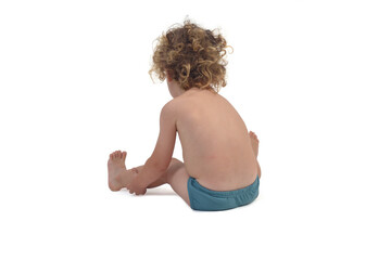 back view of boy in underpants sitting on the floor on white background (3 year old)
