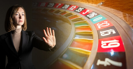 Woman resists gambling addiction. Roulette table in casino. Girl makes hundred gesture. Woman...