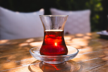Tea in a glass cup on the table. Turkish Tea and slim glass cup. Real Turkish Tea, red in color.