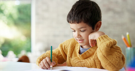 Child, drawing or boy writing homework on notebook in kindergarten education for growth...