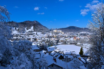 View of the town of Škofja Loka and the castle above in Gorenjska, Slovenia with forest covered Lubnik hill in the bacground