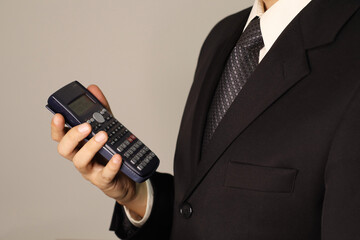 Businessman doing calculations on his scientific calculator