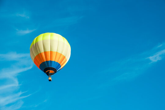 Single hot air balloons flying across the blue sky, copy space