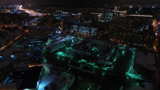 Cityscape with traffic near trolleybus park at winter evening.