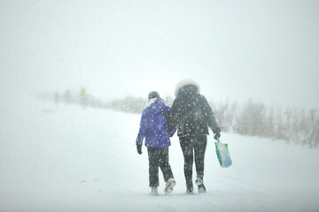 Fototapeta na wymiar Two People Walking in the Snow Carrying Bags