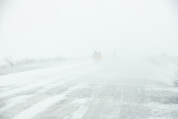 A snowstorm in the city. People are walking down the street during a snowstorm. Strong wind and snowfall. Arctic climate..