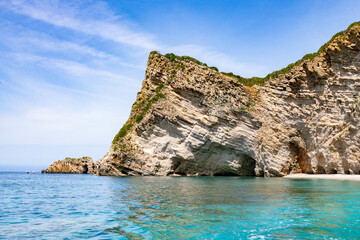 Scenic landscape of Island of Corfu, Greece, western shoreline with cliffs and caves at beach and water line of turquoise or deep blue water with breath taking limestone formations