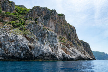 Fototapeta premium Scenic landscape of Island of Corfu, Greece, western shoreline with cliffs and caves at beach and water line of turquoise or deep blue water with breath taking limestone formations