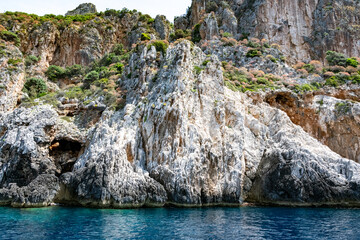 Scenic landscape of Island of Corfu, Greece, western shoreline with cliffs and caves at beach and water line of turquoise or deep blue water with breath taking limestone formations