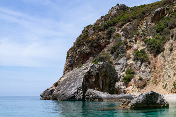 Scenic landscape of Island of Corfu, Greece, western shoreline with cliffs and caves at beach and water line of turquoise or deep blue water with breath taking limestone formations