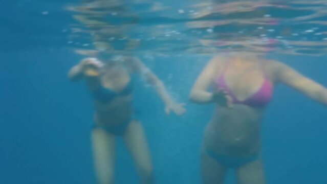 Head of two women on water and bodies underwater in Sea