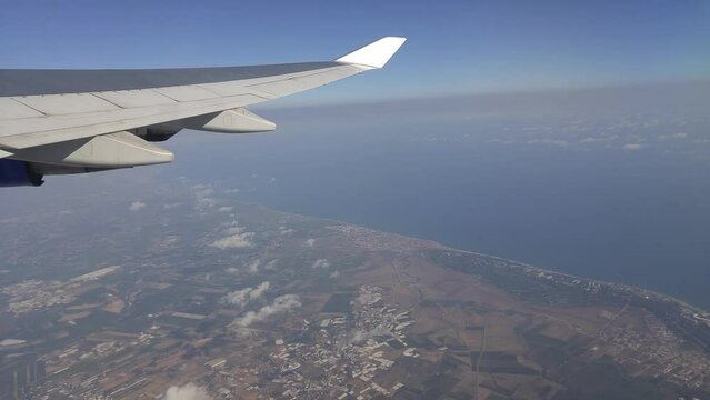 View from window of airplane to wing in sky, Turkey land and Mediterranean sea