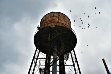 Creepy water tower outside abandoned factory 