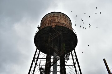 Creepy water tower outside abandoned factory 