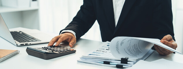 Corporate accountant use calculator to calculate and maximize tax refunds and improve financial...